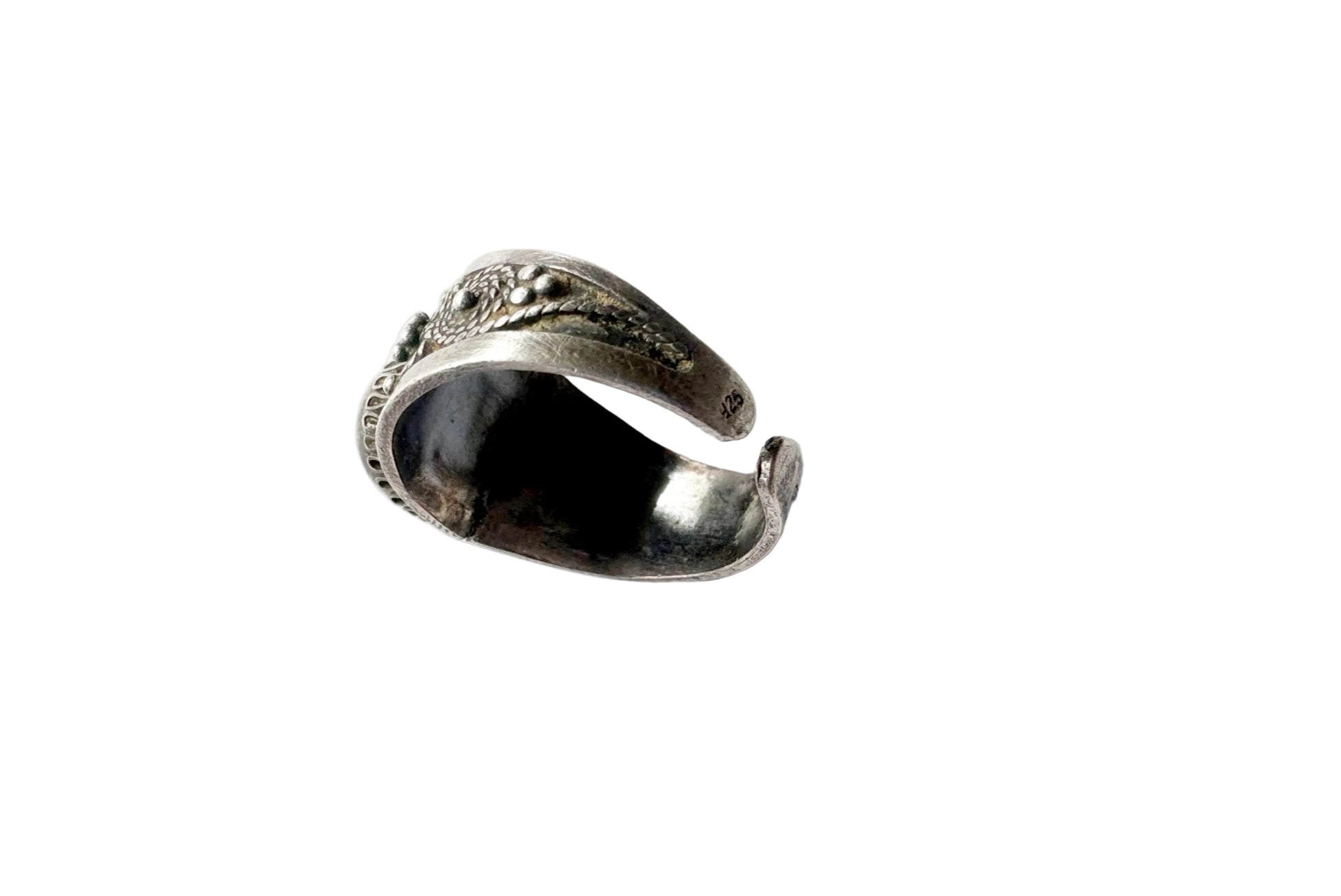 A vintage sterling silver cuff ring with oxidized detailing, photographed on a white surface.