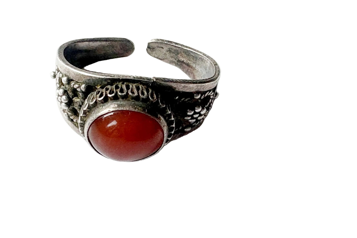 A silver-toned adjustable ring with a large oval red cabochon gemstone, photographed on a plain white background.