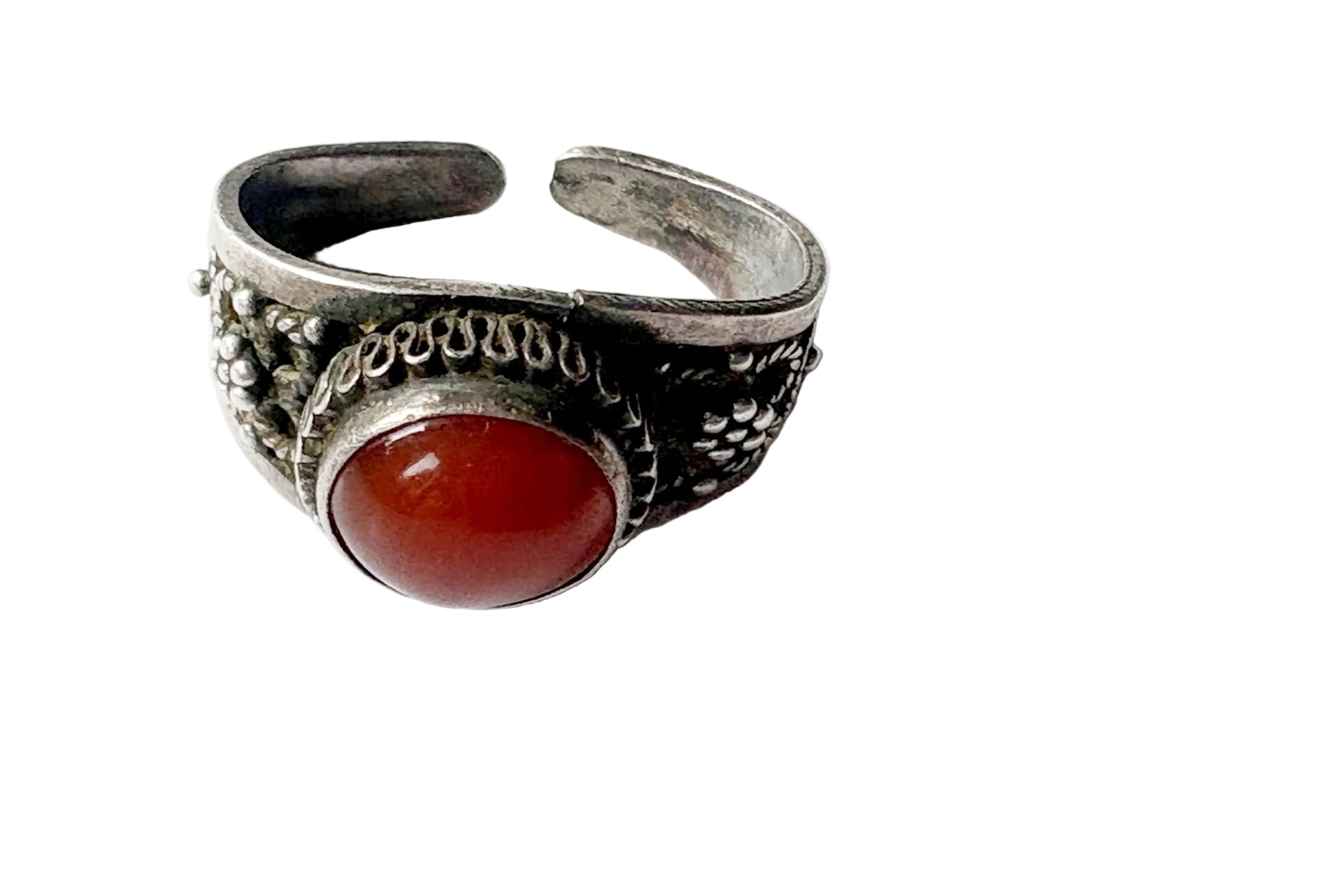 A silver-toned adjustable ring with a large oval red cabochon gemstone, photographed on a plain white background.