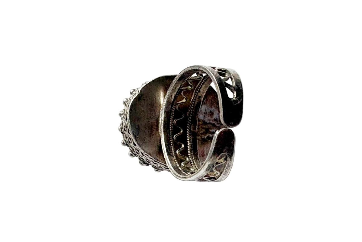A vintage silver ring with a dark oxidized interior, photographed on a light white surface.