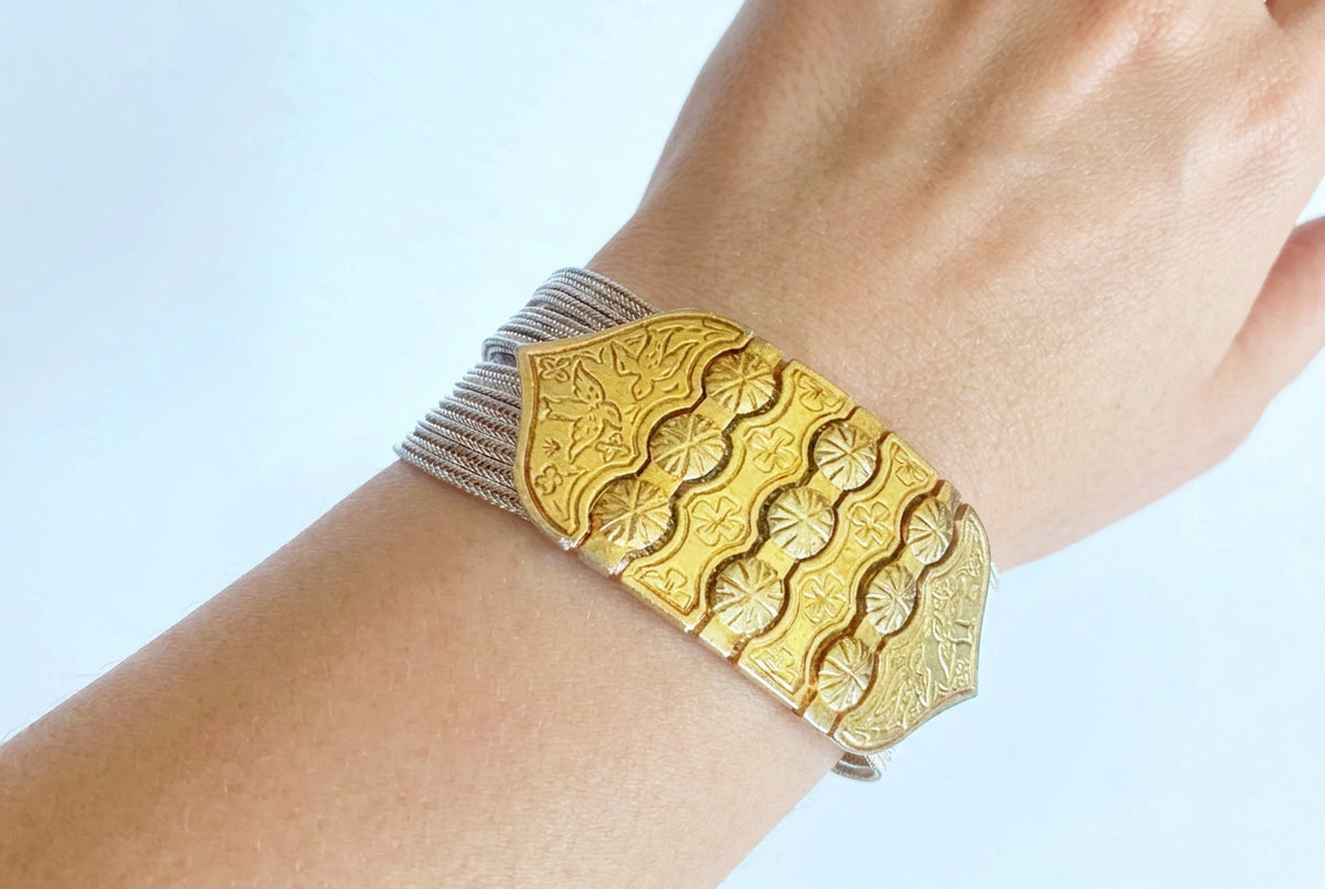 gold and silver chain bracelet on arm