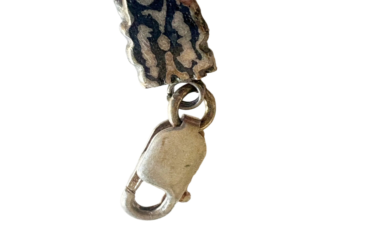 lobster claw closure of a niello chain bracelet on a white background