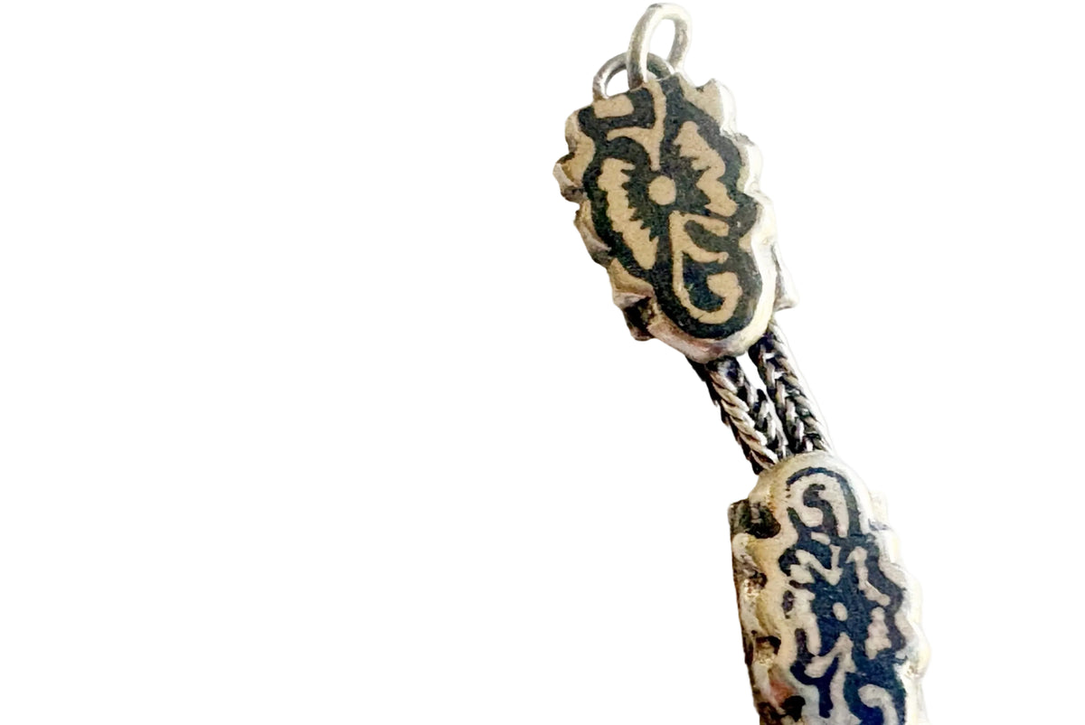 Details of a silver and niello chain bracelet on a white background