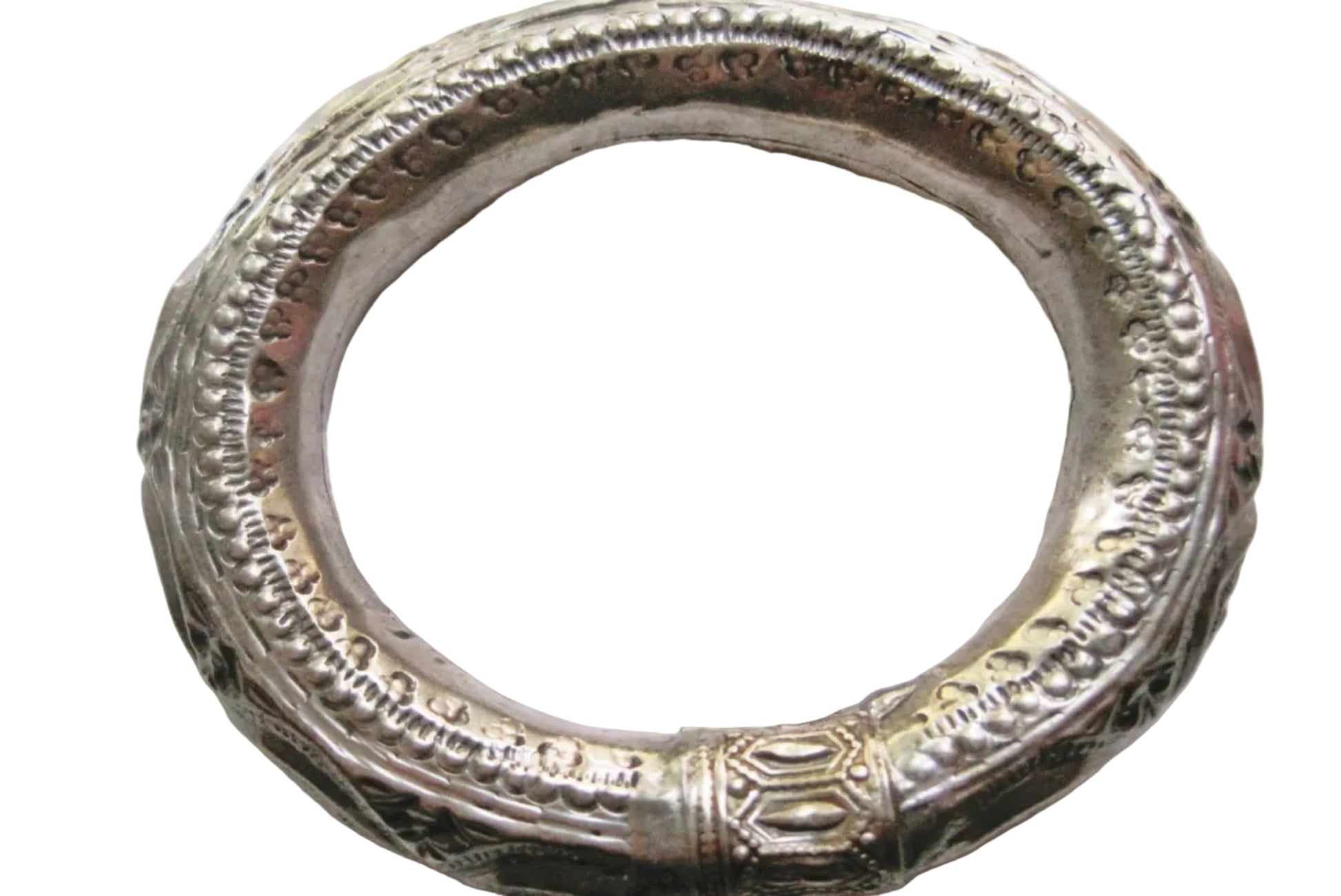 An ornate silver bracelet with intricate embossed patterns and a textured finish, photographed on a plain light background.