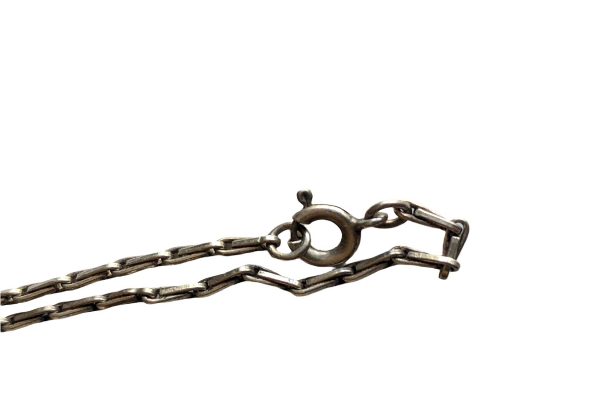 Close-up of a silver chain with a clasp on a light gray background