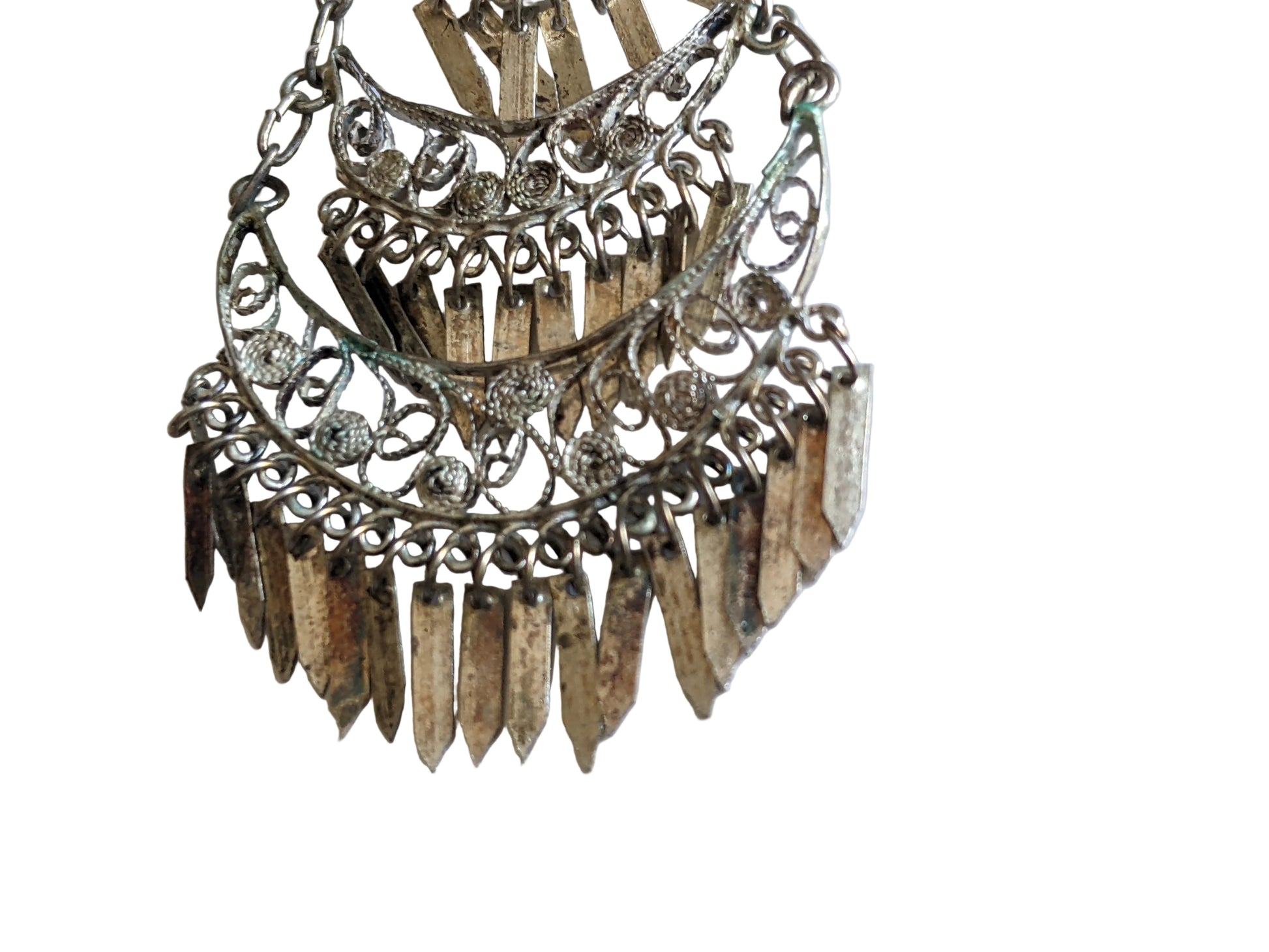 Details of a filigree earring on a white background