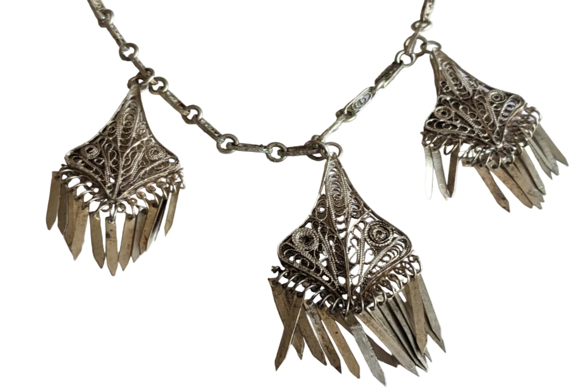 Decorative silver necklace with intricate designs on a white background