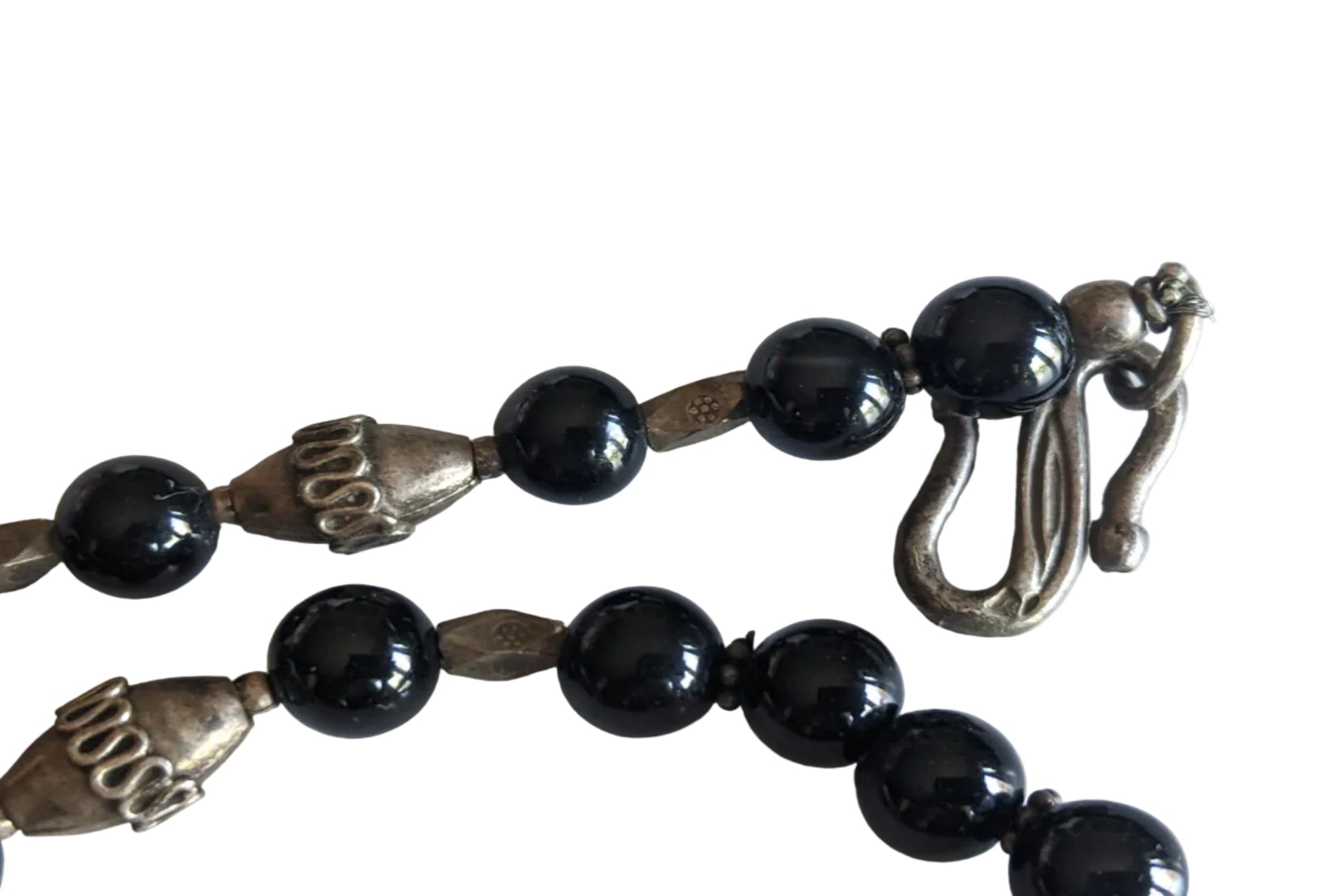 S-shaped silver clasp with an assay mark on a white background