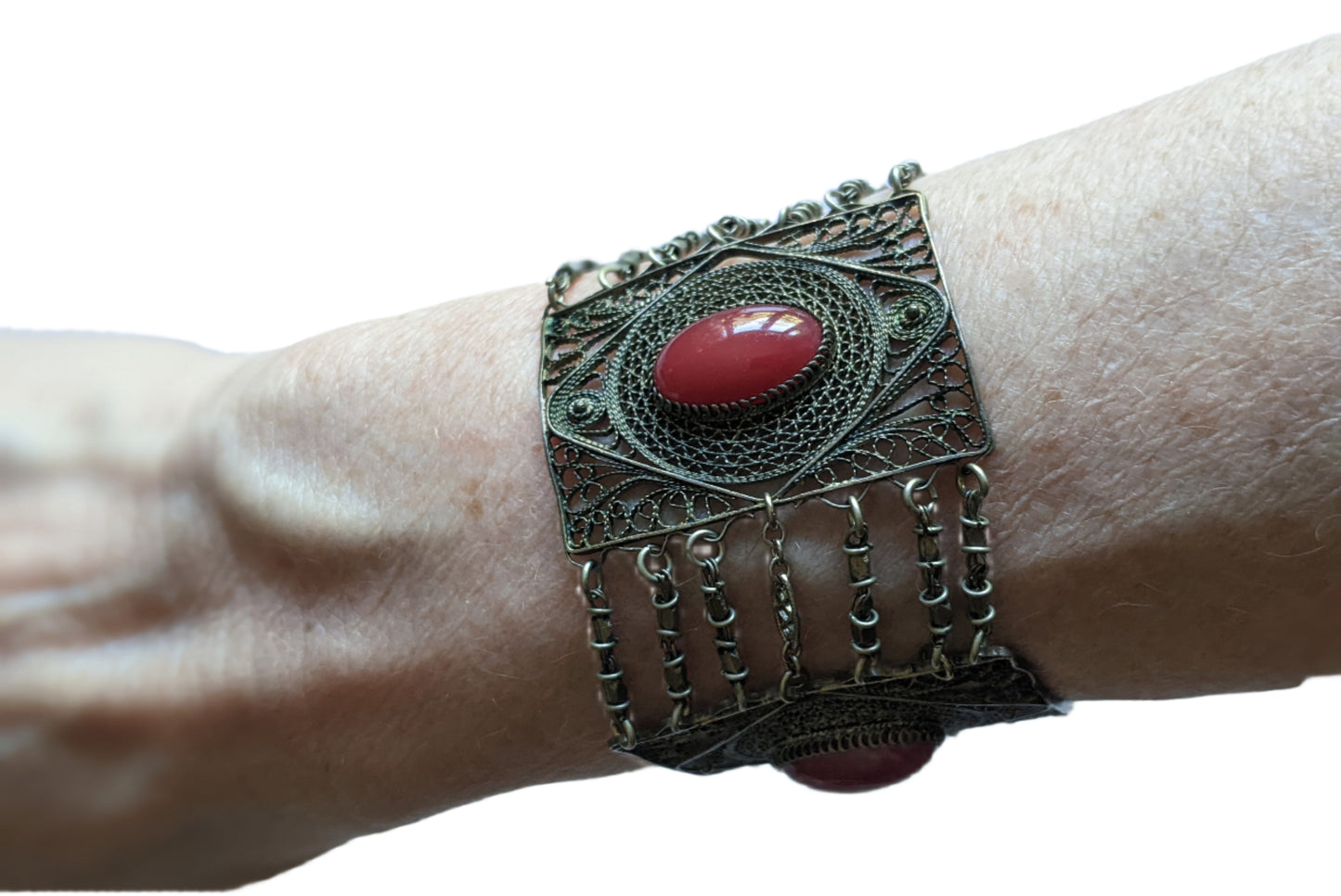 Silver Filigree bracelet with carnelian on a wrist on a white background