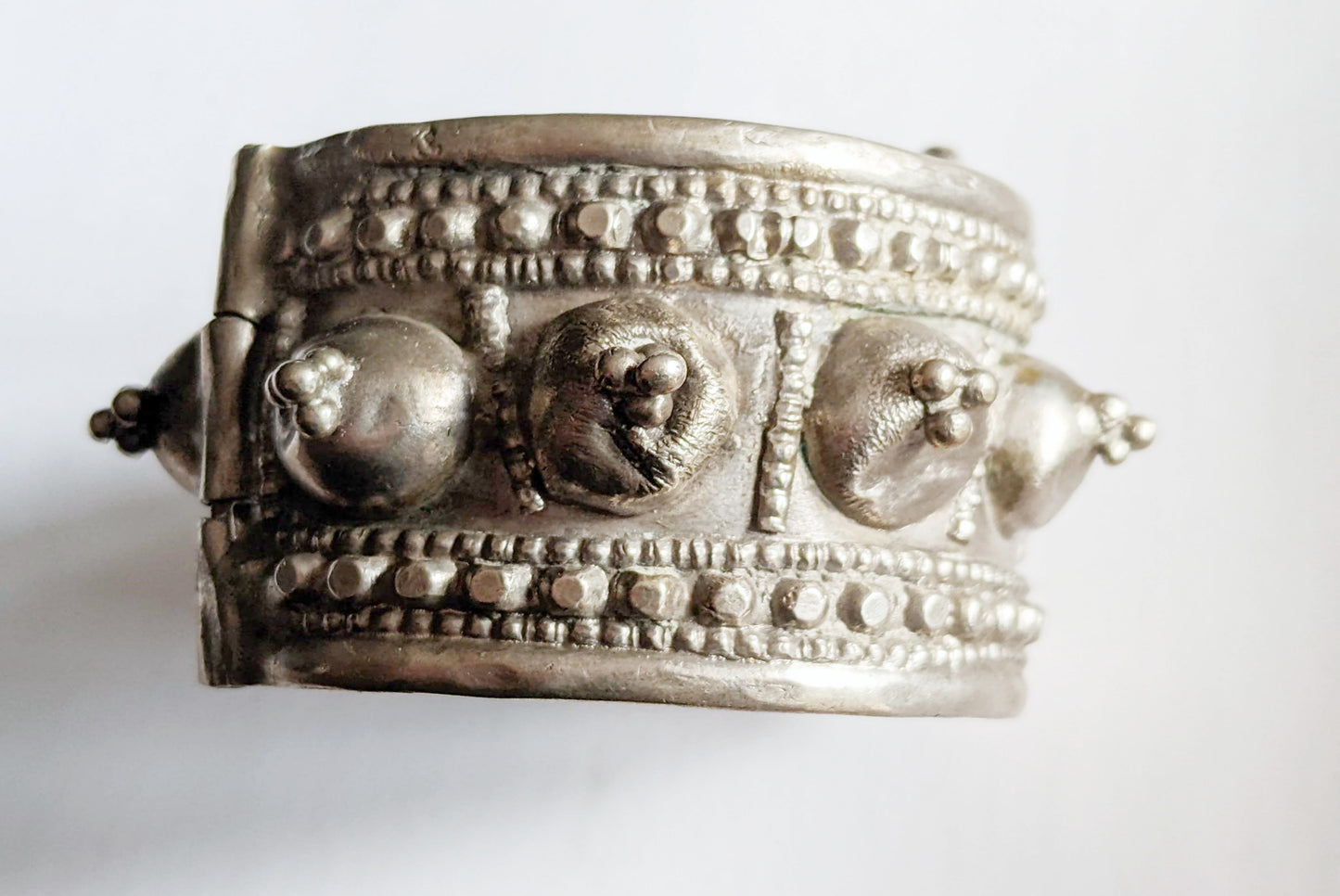 Silver bracelet with intricate designs on a white background