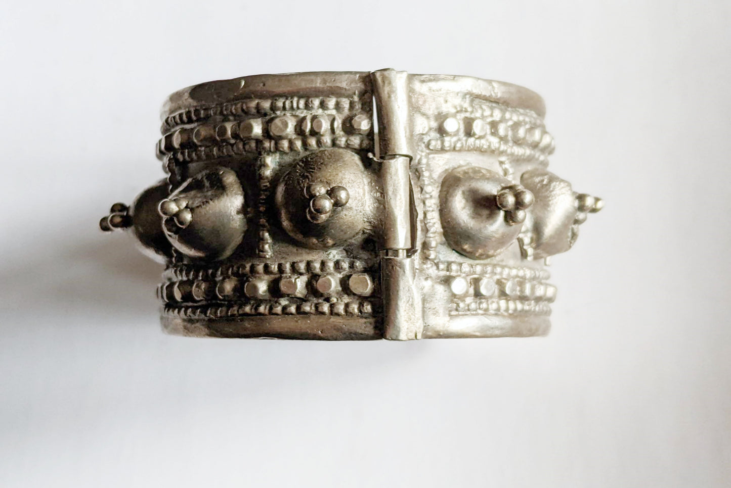 Silver bracelet with intricate designs on a white background